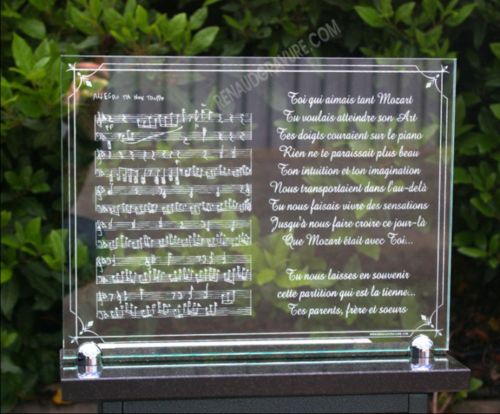 A glass funeral plaque with musical notes and music score